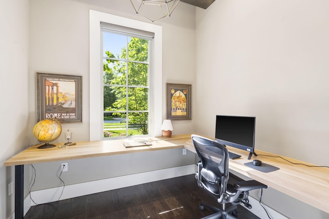 office with hardwood / wood-style flooring and an inviting chandelier