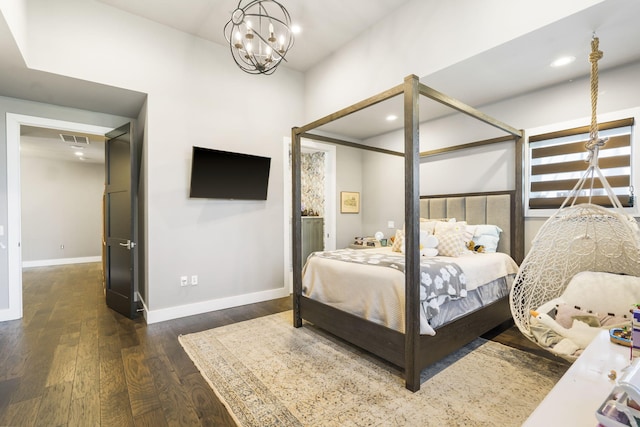 bedroom with a notable chandelier and dark hardwood / wood-style flooring