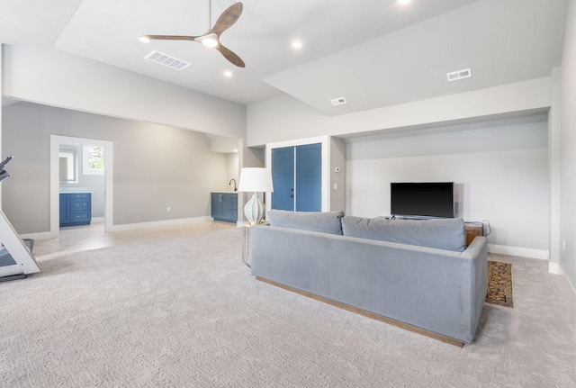 carpeted living room with ceiling fan