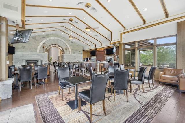 dining area with high vaulted ceiling and hardwood / wood-style flooring