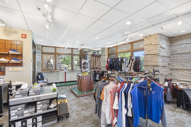 miscellaneous room with concrete flooring and a drop ceiling