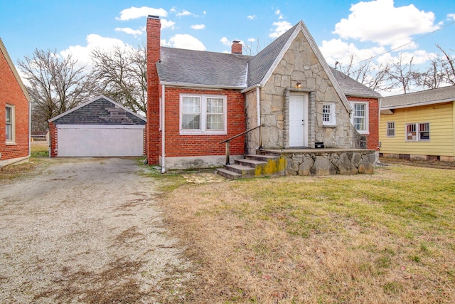 view of front of home with a garage, a front yard, and an outbuilding