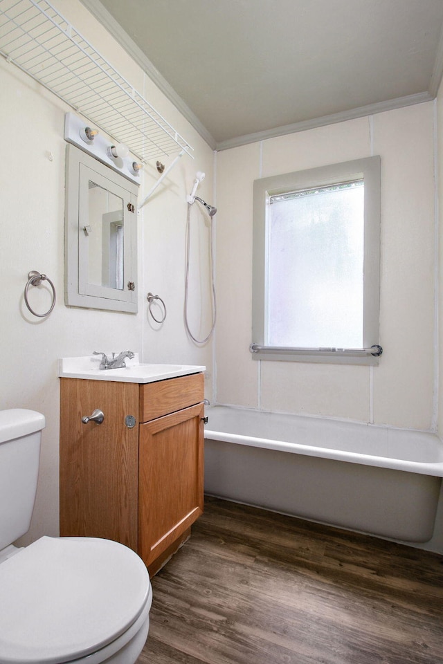 bathroom with crown molding, hardwood / wood-style flooring, vanity, and toilet