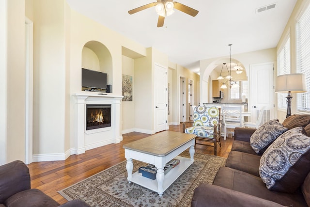 living room featuring ceiling fan with notable chandelier and hardwood / wood-style flooring