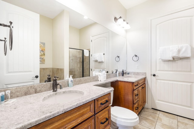 bathroom with tile patterned flooring, walk in shower, vanity, and toilet