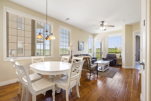 dining space featuring ceiling fan with notable chandelier and dark hardwood / wood-style floors