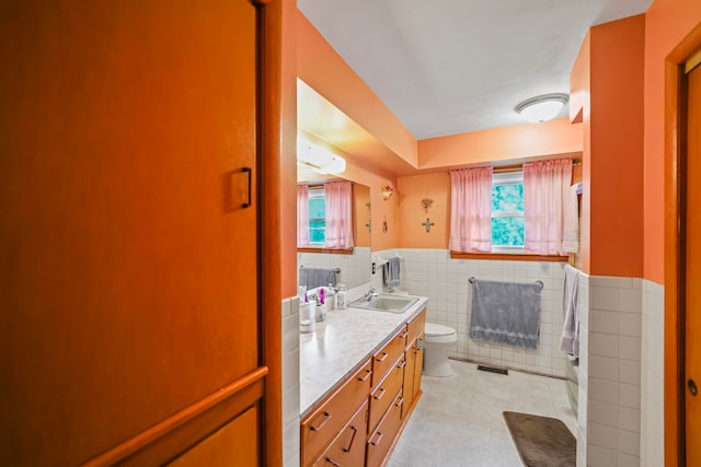 bathroom featuring tile walls, vanity, and toilet