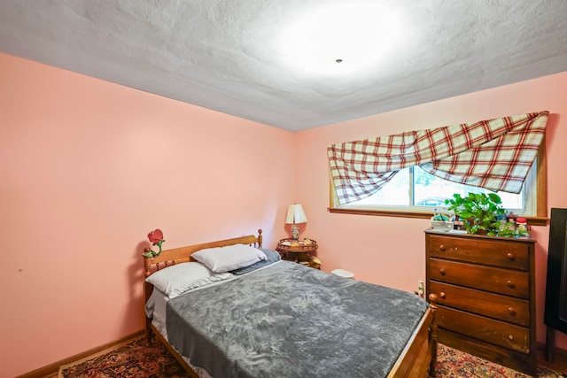 bedroom with dark wood-type flooring and a textured ceiling