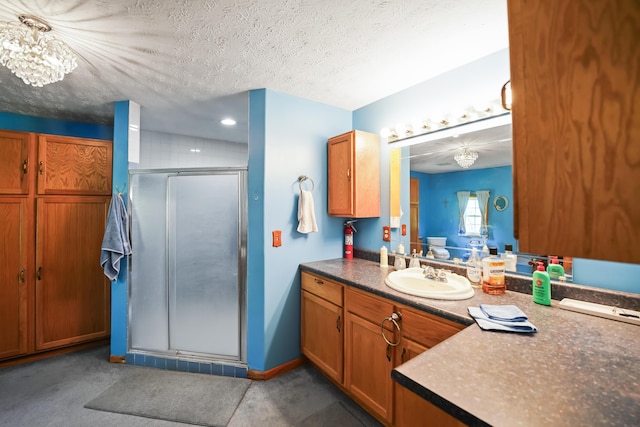 4587 E Farm Road 136, Springfield, MO 65809 - bathroom featuring a shower stall, an inviting chandelier, vanity, baseboards, and a textured ceiling