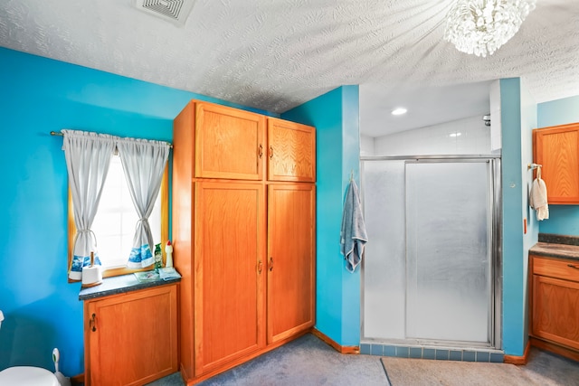 bathroom featuring vanity, walk in shower, an inviting chandelier, and a textured ceiling