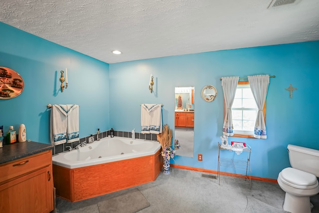 bathroom featuring vanity, a bathtub, toilet, and a textured ceiling