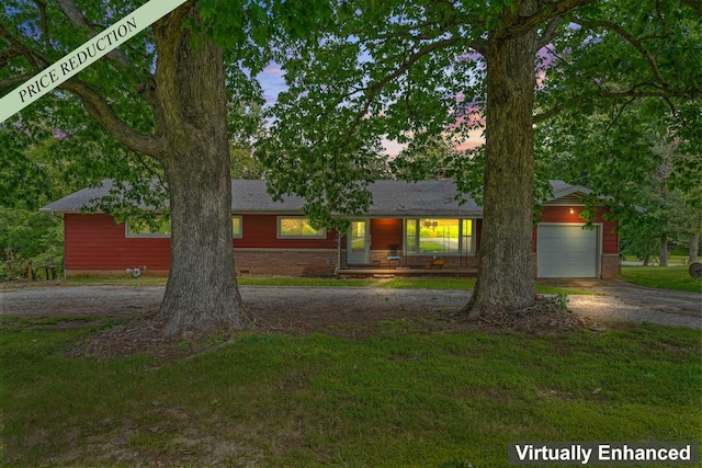 single story home featuring a lawn and a garage