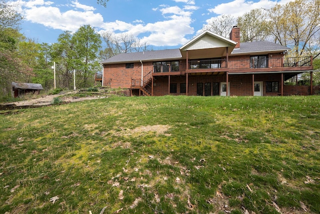 back of house featuring a lawn, brick siding, stairs, and a deck
