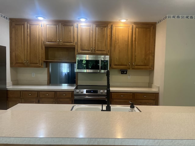 kitchen with a sink, stainless steel appliances, and light countertops