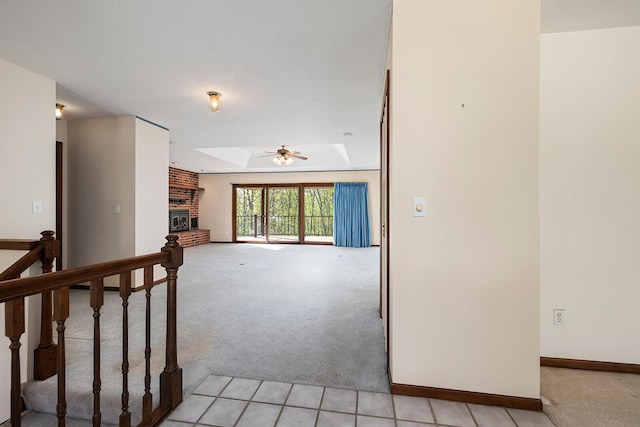 hallway with a skylight, light carpet, and baseboards