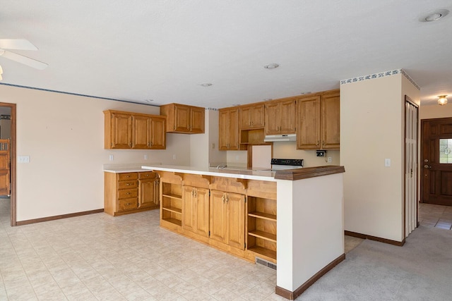 kitchen with open shelves, baseboards, range, and under cabinet range hood