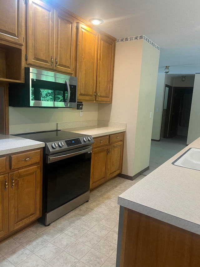 kitchen with electric stove and sink