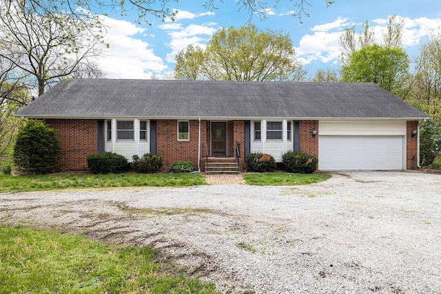 single story home with brick siding and gravel driveway