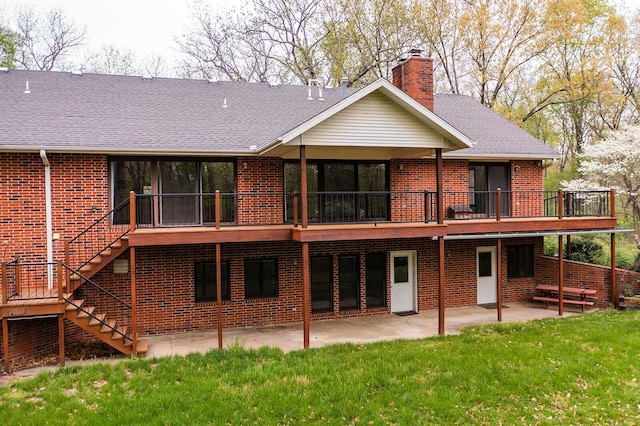rear view of property featuring stairway, a yard, a patio area, a wooden deck, and brick siding