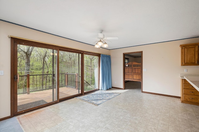 unfurnished living room with baseboards, a ceiling fan, and plenty of natural light
