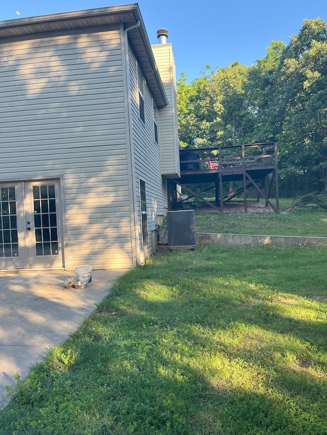 2800 Briaroaks Ln, Joplin, MO 64804 - view of home's exterior featuring a chimney, central AC, french doors, and a lawn