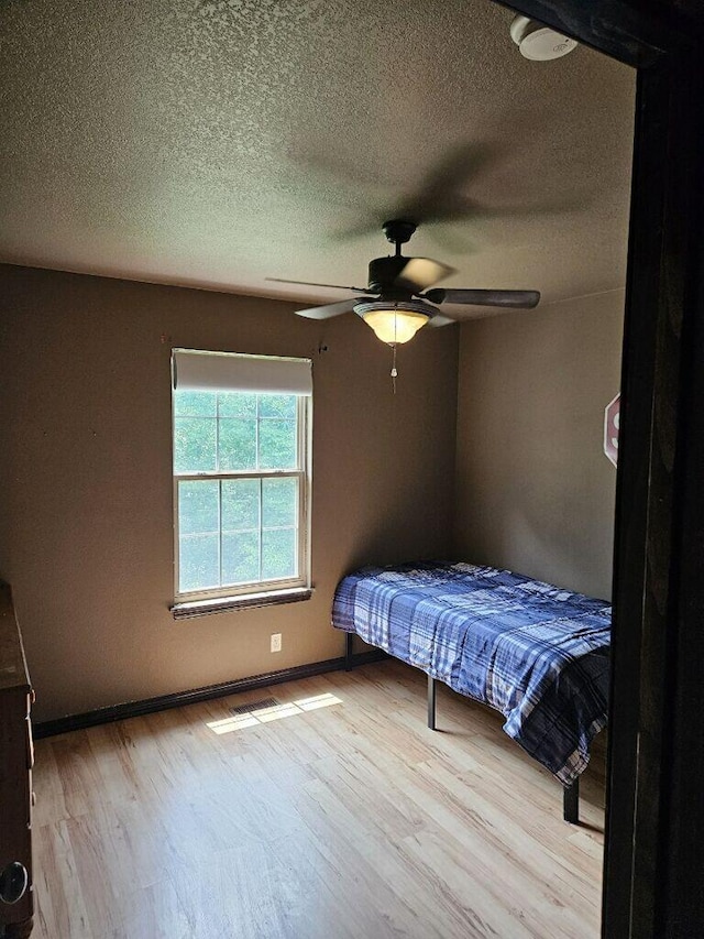 2800 Briaroaks Ln, Joplin, MO 64804 - bedroom with wood finished floors, visible vents, a ceiling fan, baseboards, and a textured ceiling