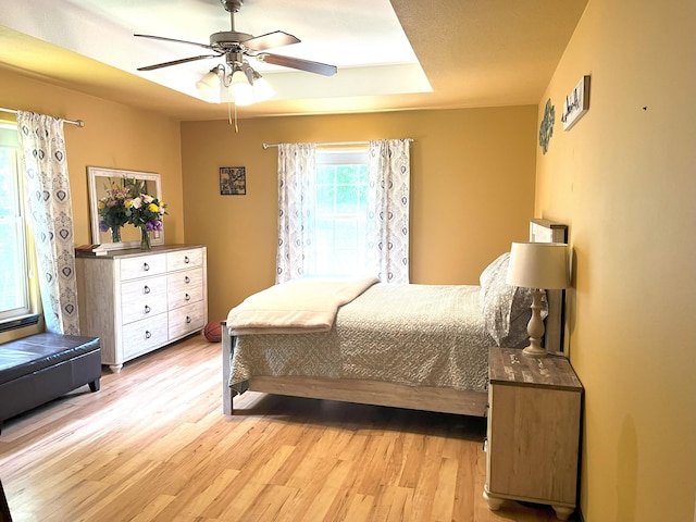 2800 Briaroaks Ln, Joplin, MO 64804 - bedroom with a tray ceiling, light wood finished floors, and ceiling fan
