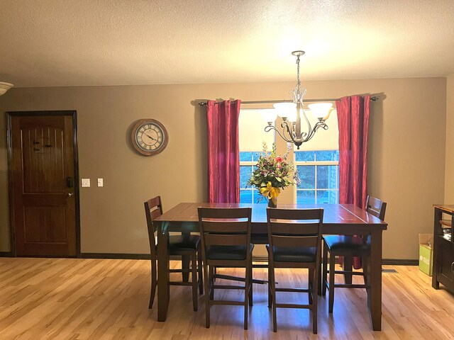 2800 Briaroaks Ln, Joplin, MO 64804 - dining space featuring light wood-style floors, a textured ceiling, and an inviting chandelier