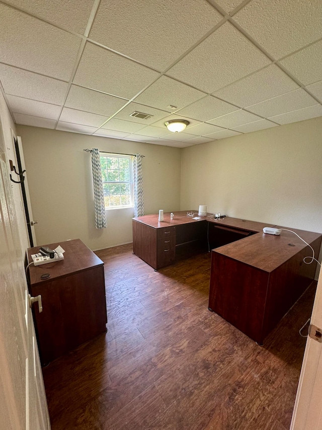 unfurnished office with a drop ceiling and dark hardwood / wood-style floors