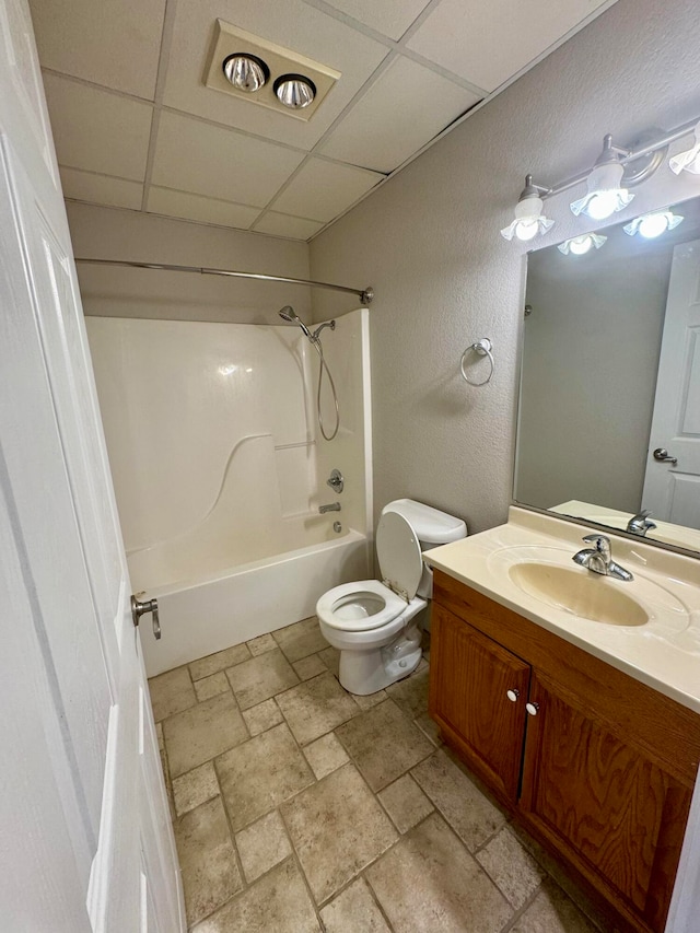 full bathroom featuring a paneled ceiling, shower / bathing tub combination, toilet, and vanity