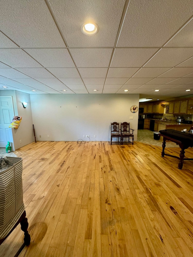 interior space featuring a paneled ceiling and light hardwood / wood-style floors