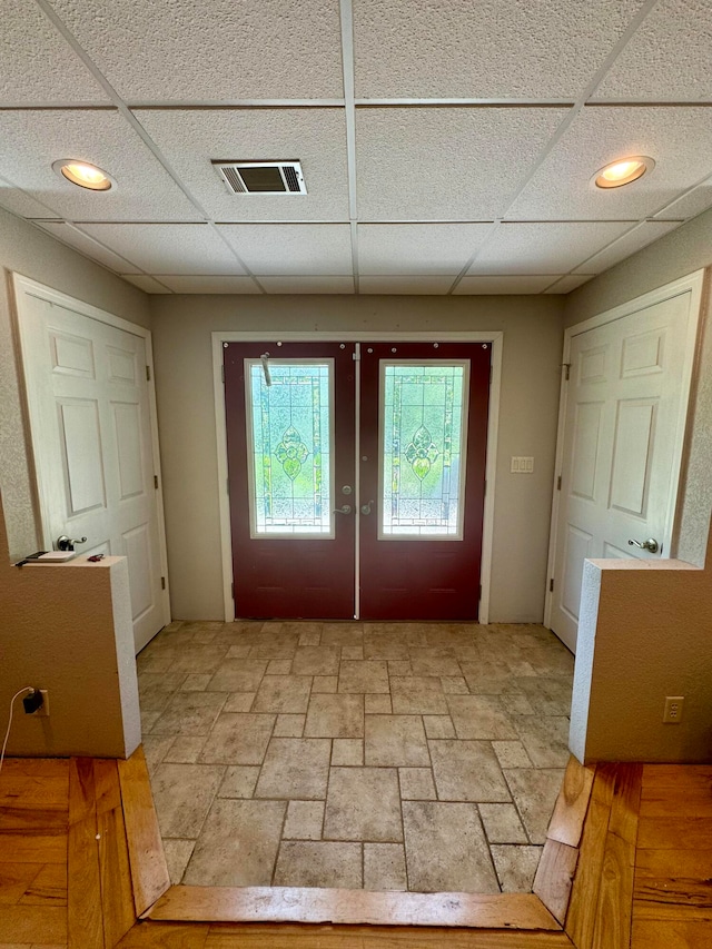 doorway to outside with french doors and a drop ceiling