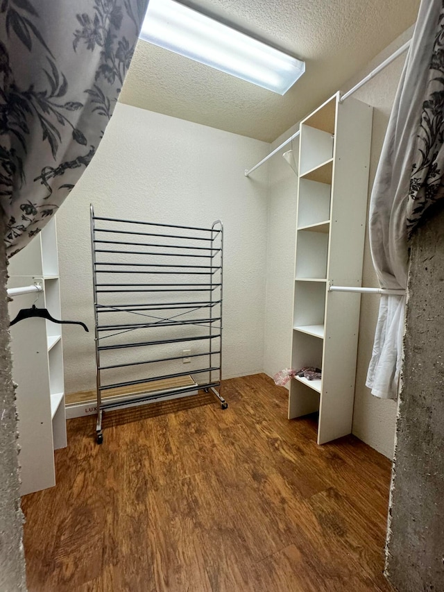 walk in closet with hardwood / wood-style flooring