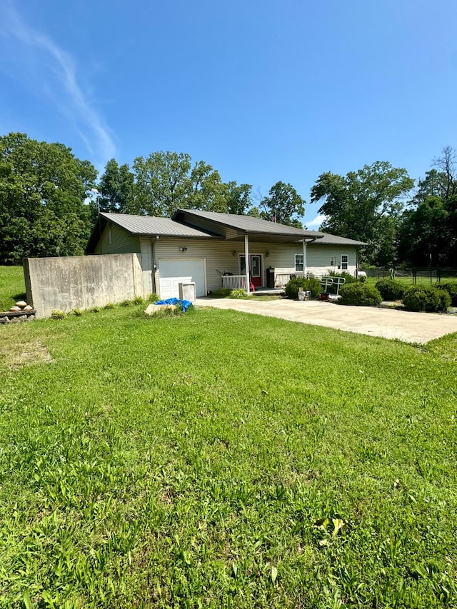 back of house with a garage and a lawn