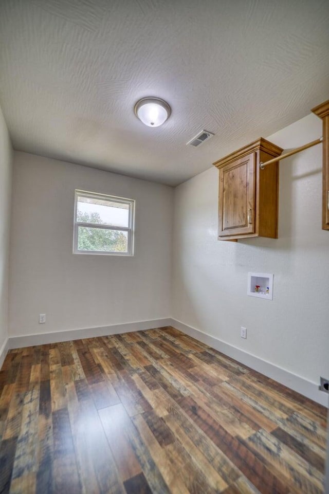 interior space featuring a textured ceiling and dark wood-type flooring