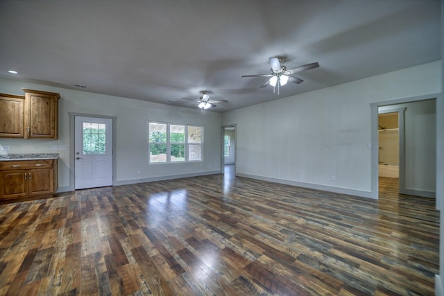 unfurnished living room featuring dark hardwood / wood-style floors and ceiling fan