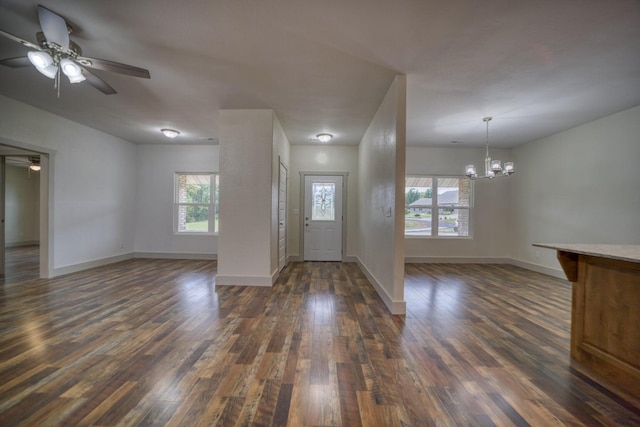 foyer entrance featuring ceiling fan with notable chandelier, dark wood-type flooring, and a healthy amount of sunlight