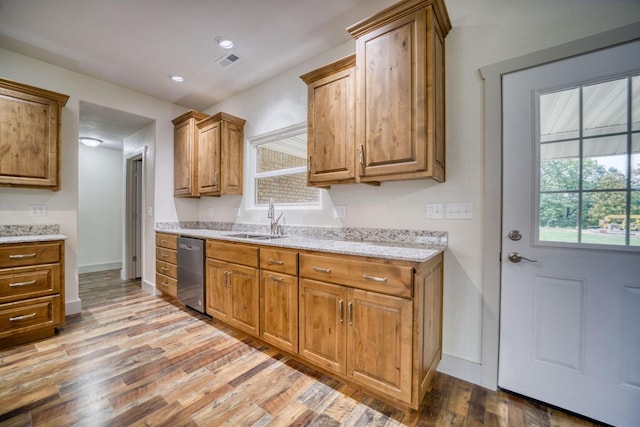 kitchen featuring dishwasher, light hardwood / wood-style flooring, sink, and light stone counters