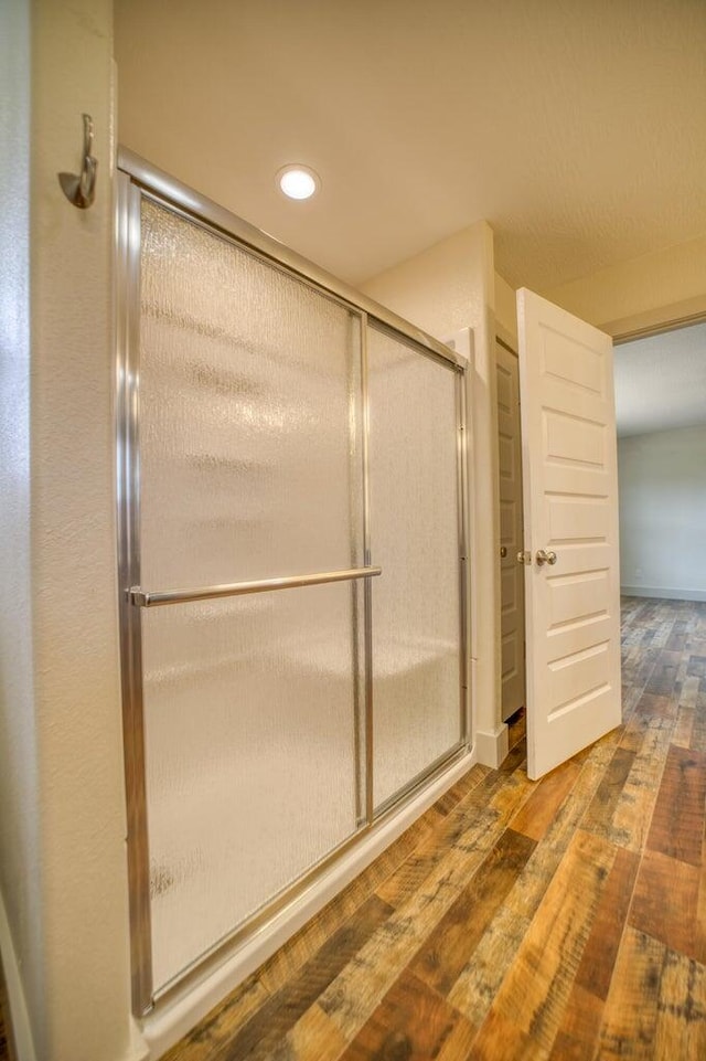 bathroom featuring hardwood / wood-style flooring and a shower with door