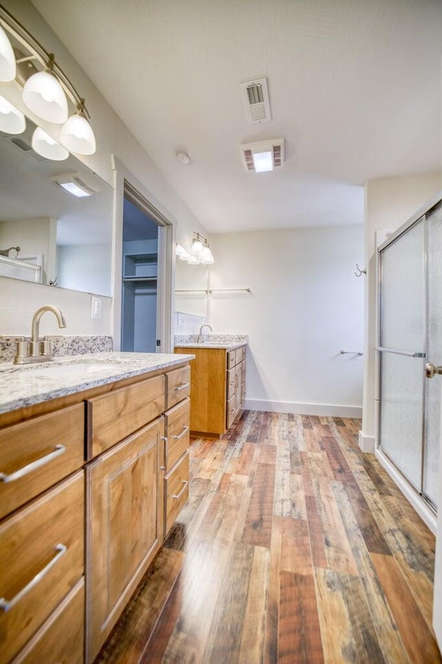 bathroom featuring a shower with door, hardwood / wood-style floors, and vanity