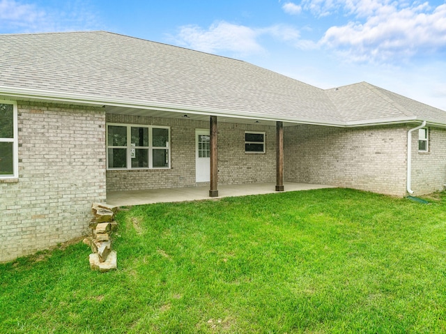 rear view of property featuring a yard and a patio