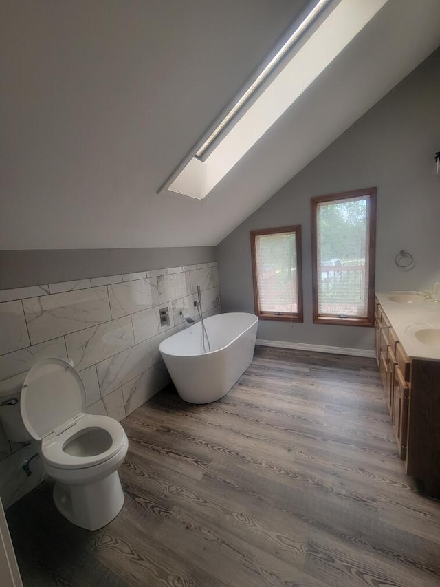 bathroom with toilet, vanity, hardwood / wood-style floors, and a washtub