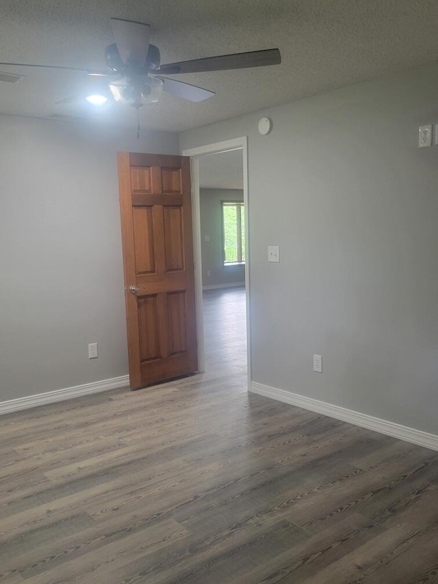 unfurnished room featuring wood-type flooring, ceiling fan, and a textured ceiling