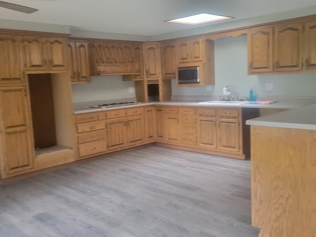 kitchen with white gas stovetop, light hardwood / wood-style floors, sink, and ceiling fan