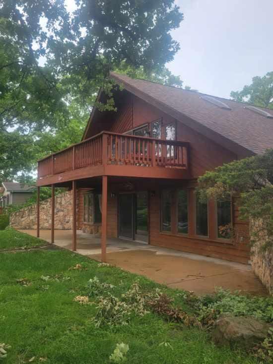 rear view of house featuring a patio area and a wooden deck