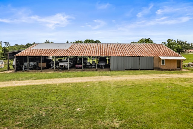 exterior space with an outdoor structure, a lawn, and a carport