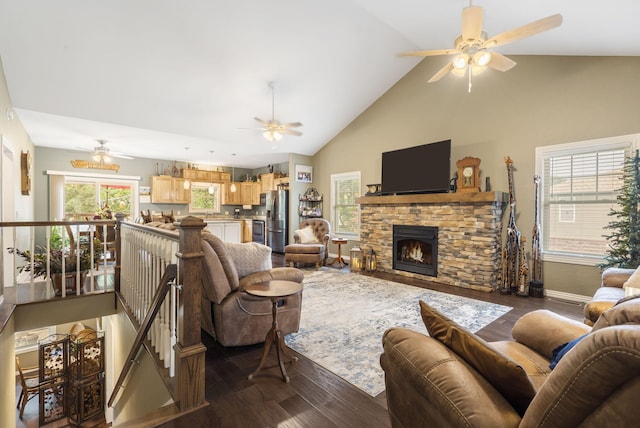 living room featuring high vaulted ceiling, a stone fireplace, and dark hardwood / wood-style floors