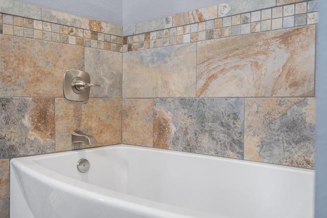 bathroom featuring a bath and a textured ceiling