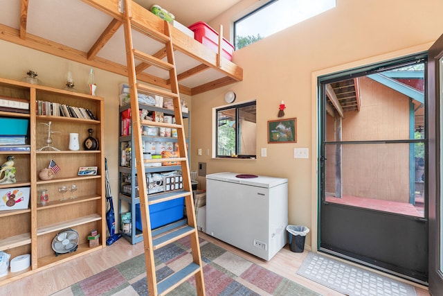 clothes washing area with hardwood / wood-style floors and a wealth of natural light