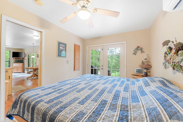 bedroom featuring a wall mounted AC, access to exterior, hardwood / wood-style flooring, and ceiling fan